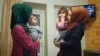 Аліє Емірусеїнова та Азізе Абхаїрова з дітьми Абхаїрових на руках