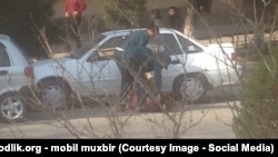 Сотрудники милиции Самарканда, которые пытаются насильно уложить женщину в багажник. Скриншот с видео мобильного репортера «Озодлик».