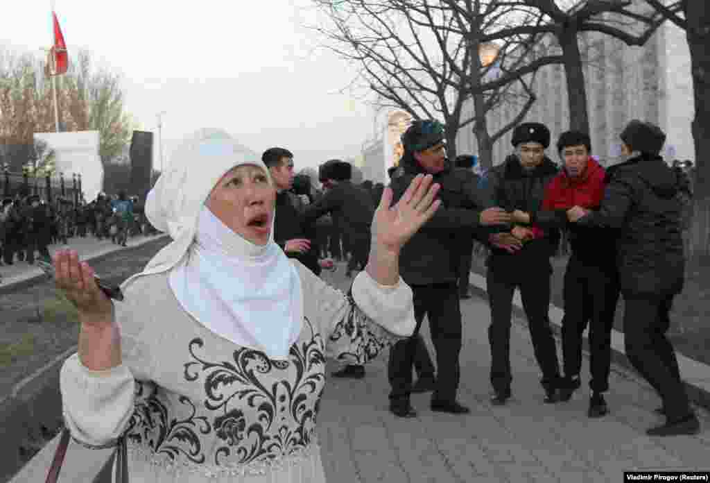 A woman reacts as police officers detain a man during a rally for supporters of jailed Kyrgyz politician Sadyr Japarov in central Bishkek. (Reuters/Vladimir Pirogov)