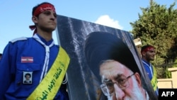 Lebanese boys hold a portrait of leader of the Islamic Republic of Iran, Ayatollah Ali Khamenei during the funeral procession of member of Hezbollah.