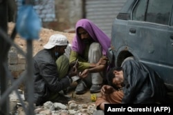 A drug user prepares to inject heroin into another user on a roadside in Rawalpindi. Meth has quickly overtaken heroin and cannabis as the drug of choice in Pakistan.