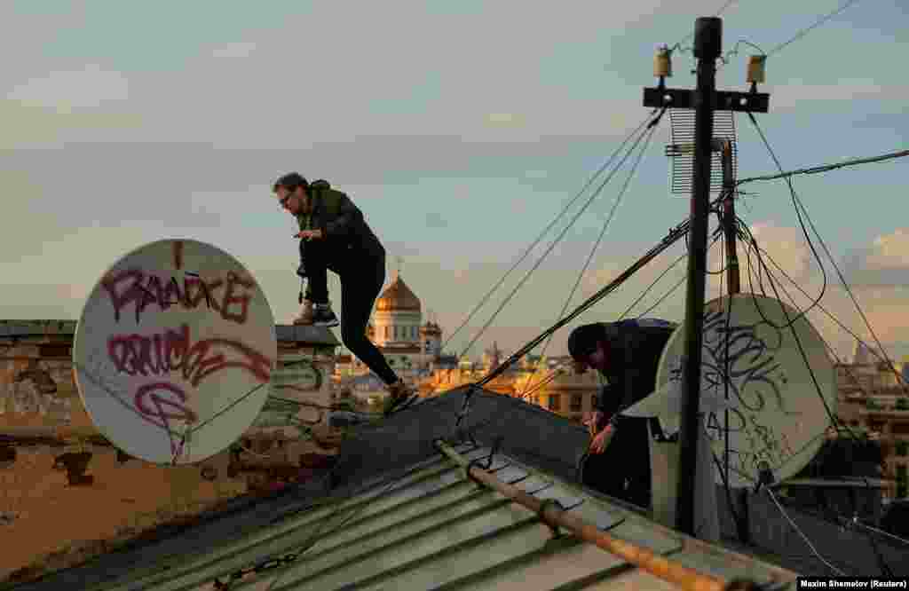 Georgy Lanchevskiy, left, and Konstantin Drykin, right, climb across a rooftop in Moscow. Drykin’s biggest climb was a 176-meter Stalin-era apartment block near the Kremlin in August, 2014. Lanchevskiy climbed in 2013 the spire of Moscow State University, which is 240 meters high. 