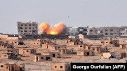 Smoke rises from buildings in the area of Bughayliyah, on the northern outskirts of Deir al-Zor on September 13.