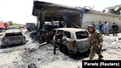 Afghan security forces inspect the site of a deadly suicide attack in Jalalabad on July 10. 