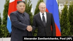 Russian President Vladimir Putin (right) and North Korea's leader Kim Jong Un shake hands during their meeting in Vladivostok on April 25, 2019.