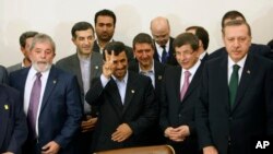 Iranian President Mahmoud Ahmadinejad, center, flashes a victory sign, as his Brazilian counterpart Luis Inacio Lula da Silva, left, Turkish Prime Minister Recep Tayyip Erdogan, right, and Turkish Foreign Minister, Ahmet Davutoglu, second right, stand, be