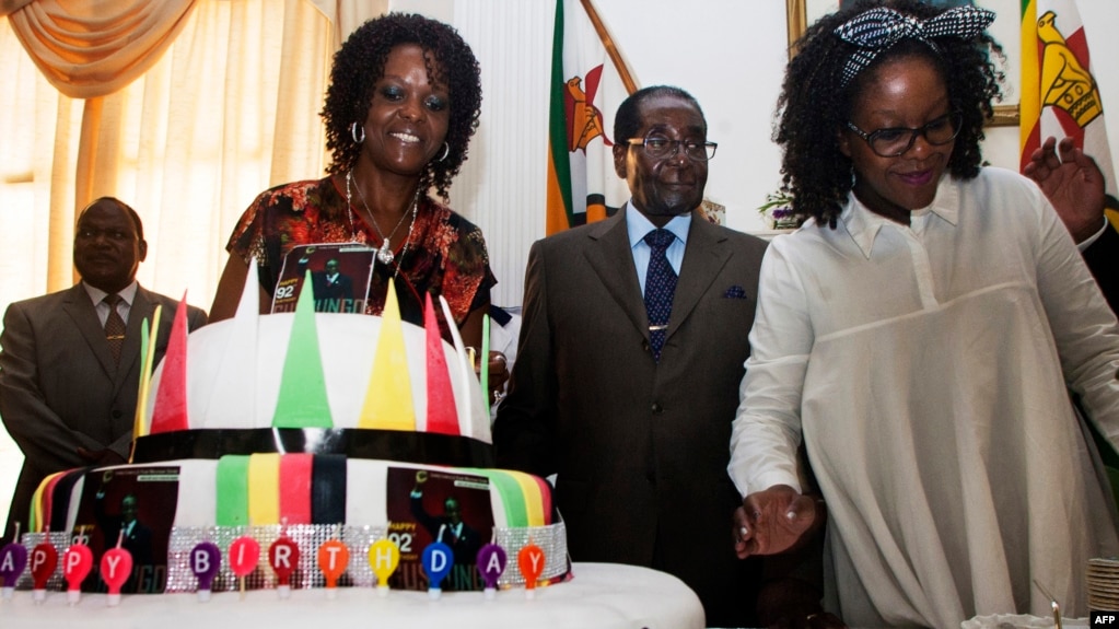 Zimbabve prezidenti Robert Mugabe (ortada) və birinci ledi Grace Mugabe (solda)