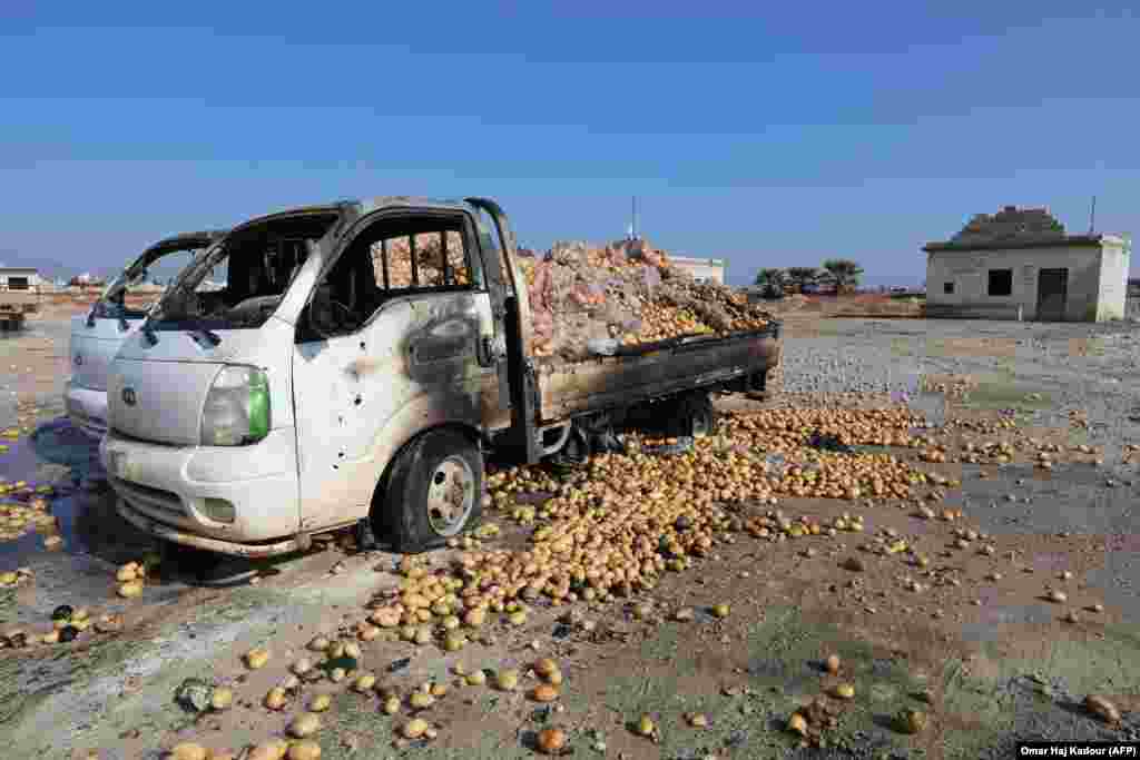 Small trucks loaded with potatoes stand abandoned following air strikes by government forces that hit a vegetable market in the town of Saraqeb in Syria's northwestern province of Idlib. (AFP/Omar Haj Kadour)