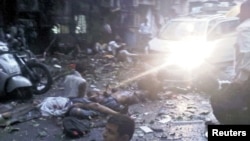 Injured people lie in the street at the site of the explosion 