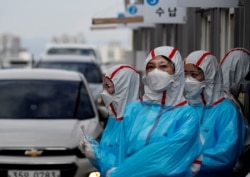 Медработники, проводящие тестирование проезжающих водителей на COVID-19 в Тэгу, Южная Корея.