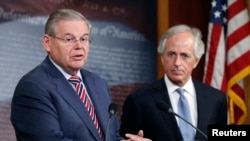 U.S. Senate Foreign Relations Committee Chairman Robert Menendez (left) and Senator Bob Corker speak to reporters after a Senate vote on an aid package for Ukraine, in Washington on March 27, 2014.