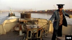 Uzbekistan -- a barge being pulled on the Amu Darya river towards the Uzbek 'Friendship Bridge', seen in background, connecting the Uzbek border town of Termez with the Afghan city of Heiraton 21Nov2001