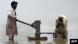 A Pakistani man drinks water from a hand-pump in a flooded area of Khyber Pakhtunkhwa Province. (file photo)
