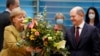 Olaf Scholz egy csokor virágot ad Angela Merkelnek a kabinetülés előtt Berlinben 2021. november 24-én