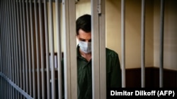 Trevor Reed, charged with attacking police, stands inside a defendants' cage during his verdict hearing at a Moscow court on July 30, 2020.