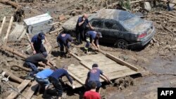 Georgia -- Rescuers and local residents collect debris at a flooded area in the Georgian capital Tbilisi, June 15, 2015