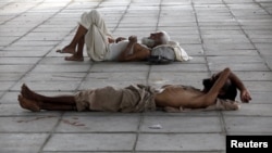 Men sleep in the shade under a bridge during intense hot weather in Karachi on June 22. 