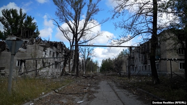 Порожні вулиці Білозерського з будинками, зруйнованими російськими ударами. На табличці одного з будинків написано: вул. Московська