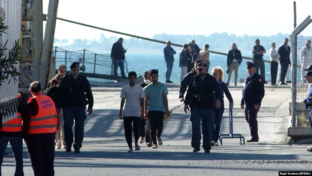 Sixteen migrants were transferred on October 16 by an Italian Navy ship to Albania to undergo what are called expedited border procedures under an agreement between Italy and Albania.