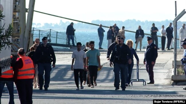 Migrantët e parë të ardhur nga Italia, teksa hynë në qendrën pranë Portit të Shëngjinit.