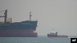 A port tender boat (right) with UN Secretary General Antonio Guterres onboard sails next to the bulk cargo ship SSI Invincible II while it is anchored at the Marmara Sea in Istanbul on August 20.