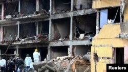 Police forensic experts examine a destroyed police station in Cinar in the southeastern city of Diyarbakir on January 14.