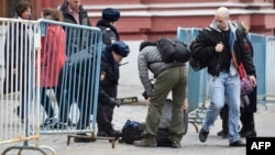 Полицейский с металлоискателем проверяет сумки прохожих через пару дней после взрыва в петербургском метро. 5 апреля 2017 года. 