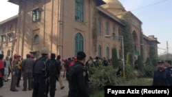 Police and rescue workers stand outside the Directorate of Agriculture Institute in Peshawar on December 1.