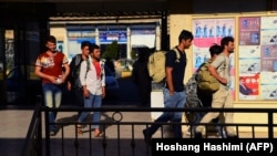 Afghan workers return from Iran carry their belongings as they arrive in the Afghan province of Herat.