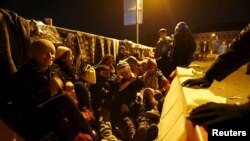 Migrants wait on the bridge at the Austrian-German border between Braunau and Simbach at lake Inn near Passau on October 27. 