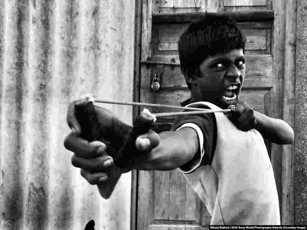Мальчик стреляет из рогатки по птицам в одном из заброшеных районов Мумбая.&nbsp;