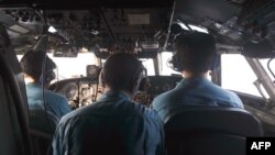 The crew of an airborne Soviet-made AN-26 being used as a search aircraft by the Vietnamese Air Force look for traces of the missing Malaysia Airlines flight MH370 over the South China Sea.