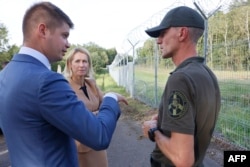 Віцэ-прэзыдэнтка Эўрапейскай камісіі Кая Калас зь міністрам унутраных спраў Літвы Мартынасам Катэлінасам (зьлева) і намесьнікам камандзіра Службы аховы дзяржаўнай мяжы Данатасам Скарнулісам на памежнай заставе Падварыёніс каля мяжы зь Беларусьсю ў Медніках (Medininkai)