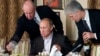 RUSSIA -- Yevgeny Prigozhin (L) assists Russian Prime Minister Vladimir Putin during a dinner with foreign scholars and journalists at the restaurant Cheval Blanc on the premises of an equestrian complex outside Moscow, November 11, 2011
