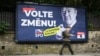 A pedestrian walks past an election billboard for a far-right party that calls on Czechs to "vote for change." 