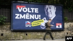 A pedestrian walks past an election billboard for a far-right party that calls on Czechs to "vote for change." 