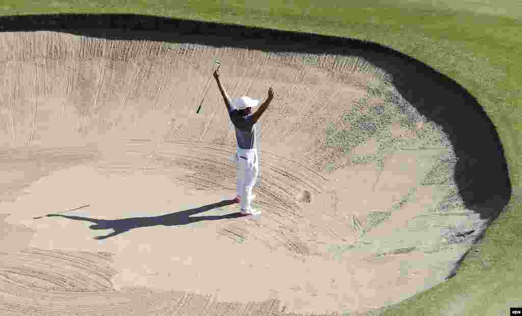 C.T. Pan of Taiwan reacts after making a shot during the men&#39;s golf tournament.