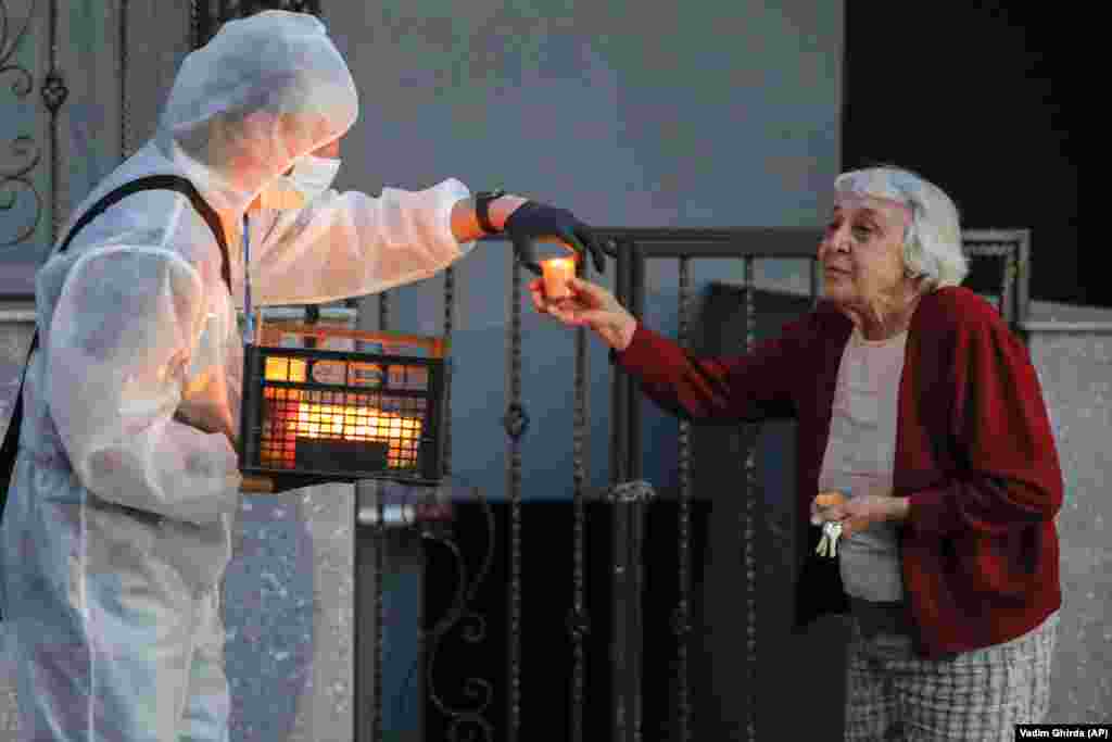A volunteer wearing a protective outfit distributes holy light in Bucharest, Romania, on April 18.