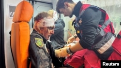 A medical worker treats a wounded police officer in an ambulance at a site of a Russian missile strike in Kharkiv on November 1.