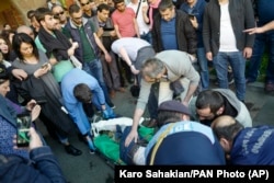 Paramedics help a protester wounded during clashes with police in Yerevan on April 16.