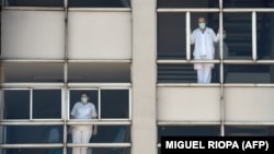 Medicinski radnici gledaju kroz prozore bolnice u Korunji, Španija, 26. mart
