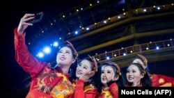 1-январь, Кытай. Бийчи кыздар Бээжиндеги жаңы жылдык кечеде селфи жасап жатышат. Ушул эле күнү Бээжинден 1100 чакырым аралыкта жайгашкан Ухань шаарында бир нече адам белгисиз ооруну жугузуп алганы үчүн жергиликтүү базар жабылган. Ошол күндөн тартып Кытайда коронавирустан 3331 адам (6-апрелге карата) каза тапты. 