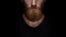 Perfect beard. Close-up of young bearded man standing against black background