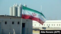 پرچم جمهوری اسلامی در نیروگاه اتمی بوشهر که گفته می‌شود تا کنون دست‌کم ۱۱ میلیارد دلار برای آن هزینه شده است