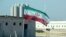 An Iranian flag flies at the Bushehr nuclear power plant, its first, during an official ceremony to kick-start work on a second reactor at the facility in 2019.