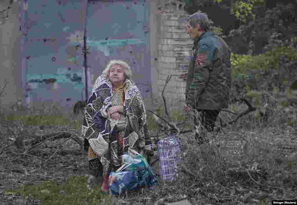 A woman sits near a damaged apartment building in Dnipro early on the morning of June 2. 