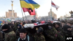 Демонстранти несуть труну Михайла Жизневський під час траурної церемонії, що відбулася на майдані Незалежності в Києві 26 січня 2014 року 