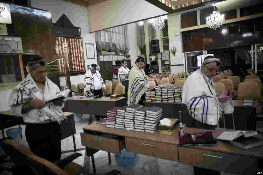 Iranian Jewish men read from the Torah during morning prayers at Youssef Abad Synagogue in Tehran. (AFP/Behrouz Mehri)