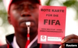 დემონსტრანტი უჩვენებს ფიფას "წითელ ბარათს" კატარისთვის მუნდიალის მასპინძლობის უფლების მიცემის გამო. ციურიხი, შვეიცარია. 2013 წლის 3 ოქტომბერი.