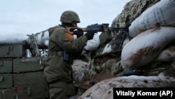 A Ukrainian soldier takes a position on the front lines near the town of Novoluhanske in the Donetsk region on December 8.